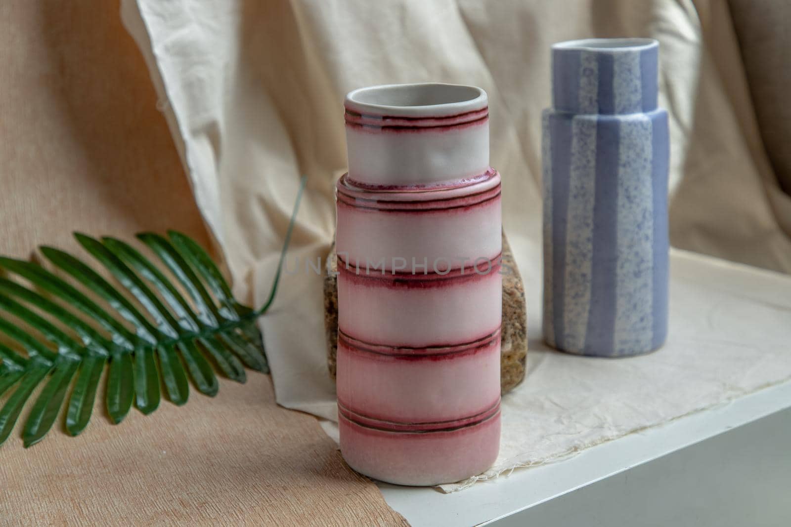 Two handmade ceramic vases on white textured table cloth. Home decor, Copy space, Selective focus.