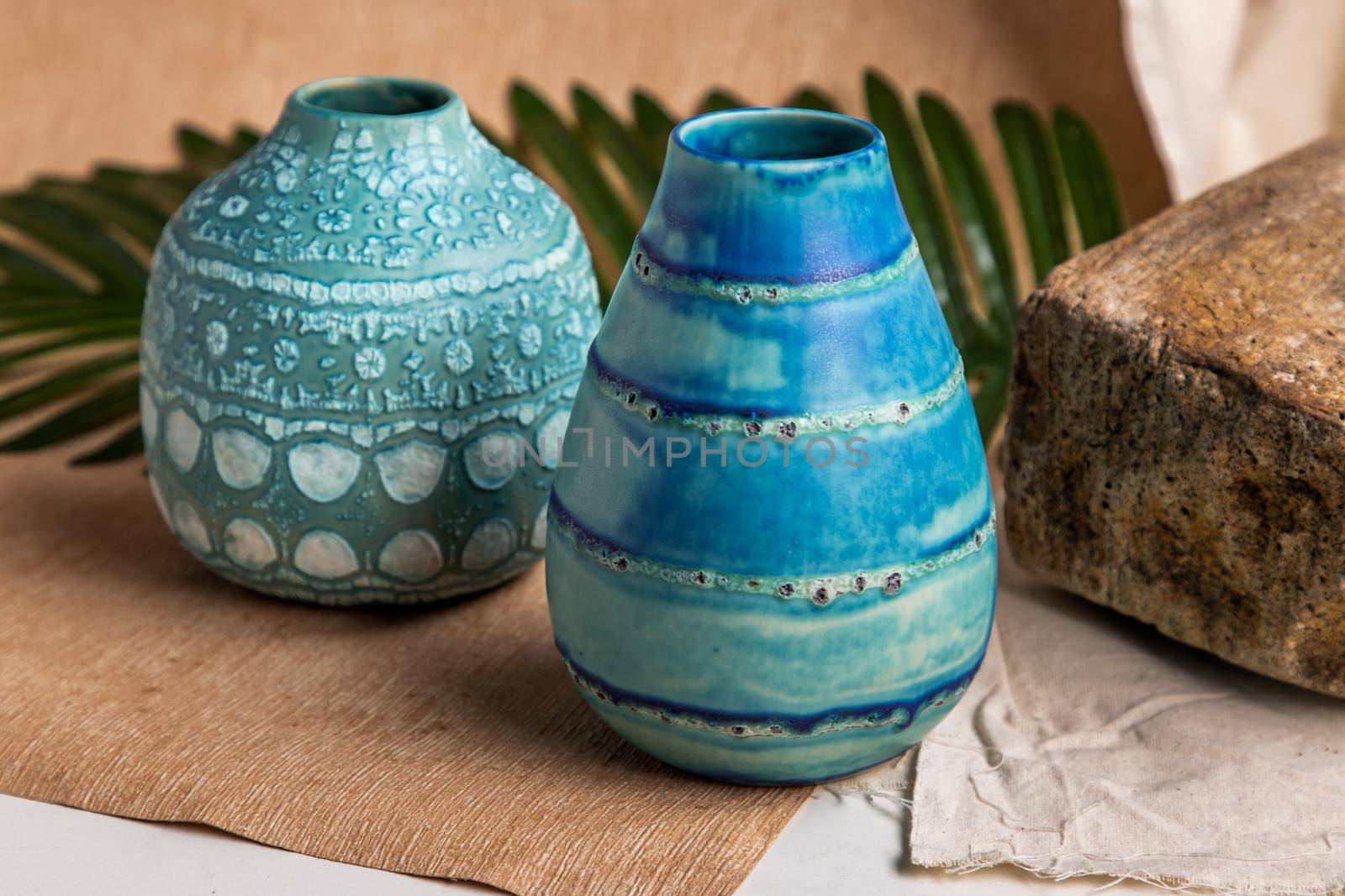 Two blue handmade ceramic vases on white textured table cloth. Home decor, Copy space, Selective focus.