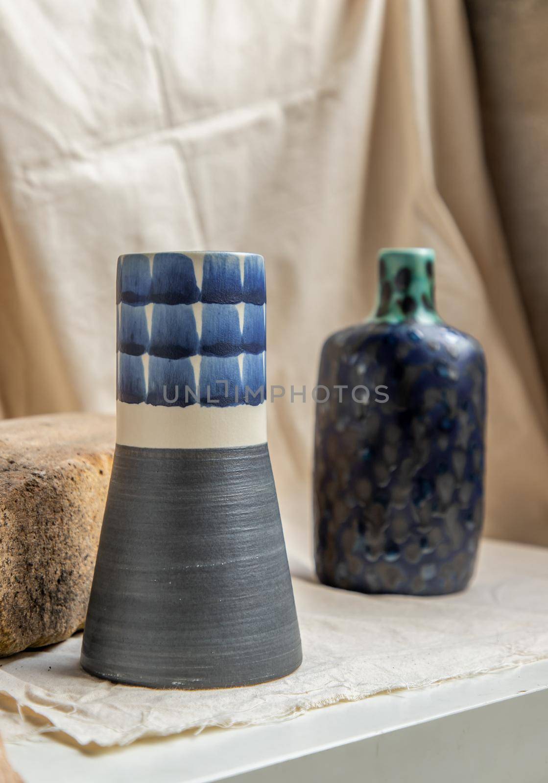 Two Blue handmade ceramic vases on white textured table cloth. Home decor, Copy space, Selective focus.