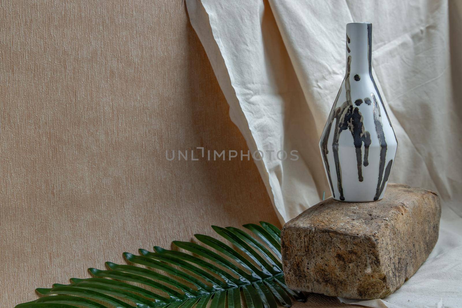 Black and White handmade ceramic vase on white textured table cloth. Home decor, Copy space, Selective focus.