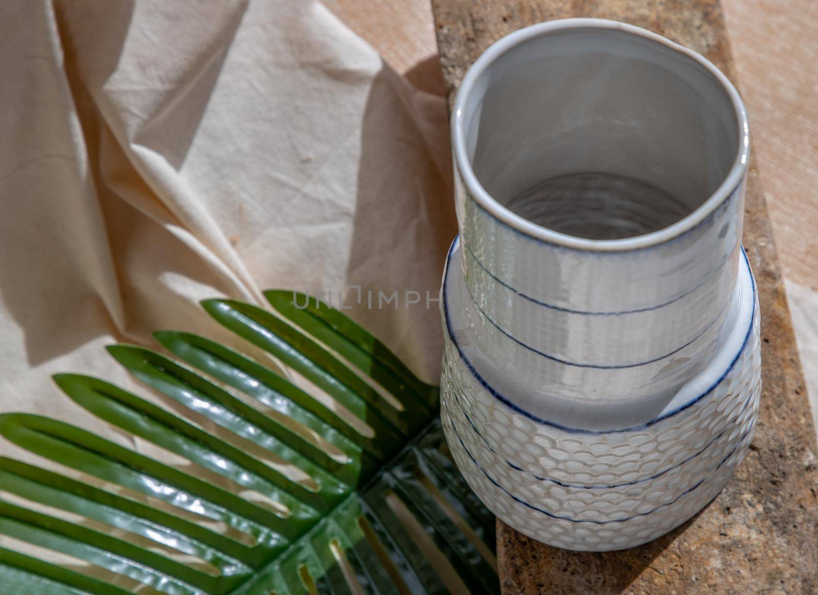White handmade ceramic vase on Stone. Home decor, Copy space, Selective focus.