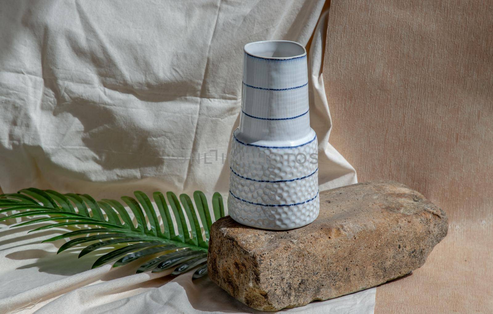White handmade ceramic vase on Stone. Home decor, Copy space, Selective focus.