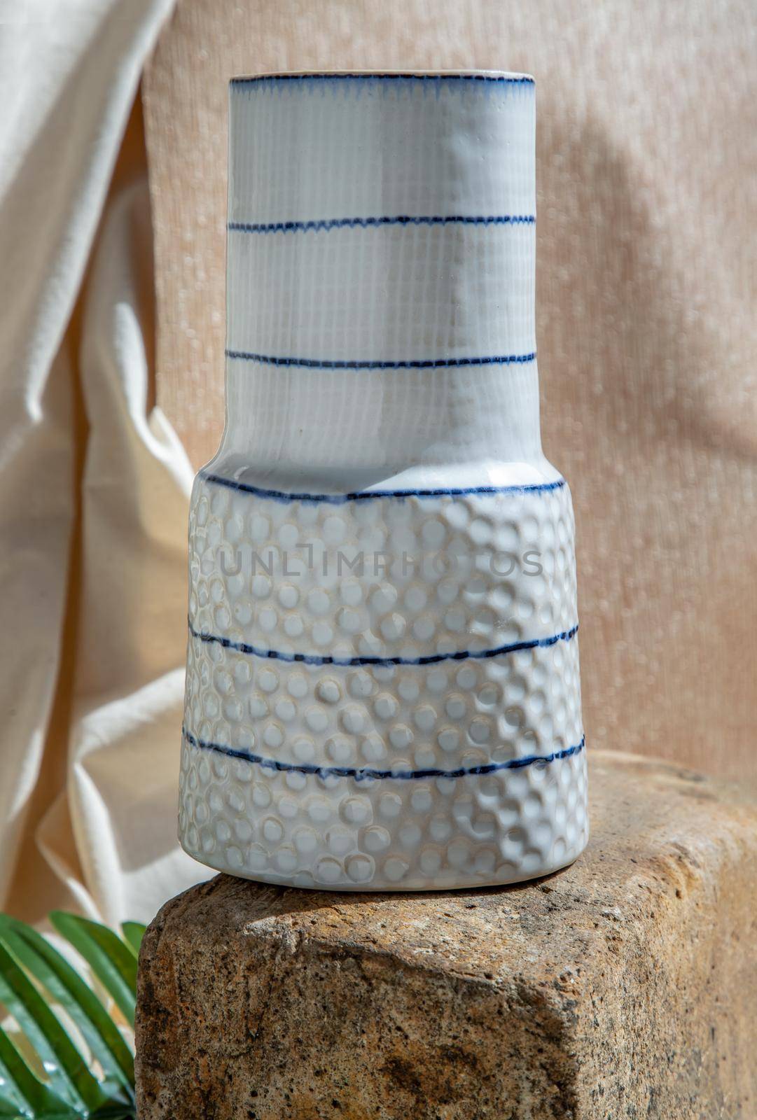 White handmade ceramic vase on Stone. Home decor, Copy space, Selective focus.