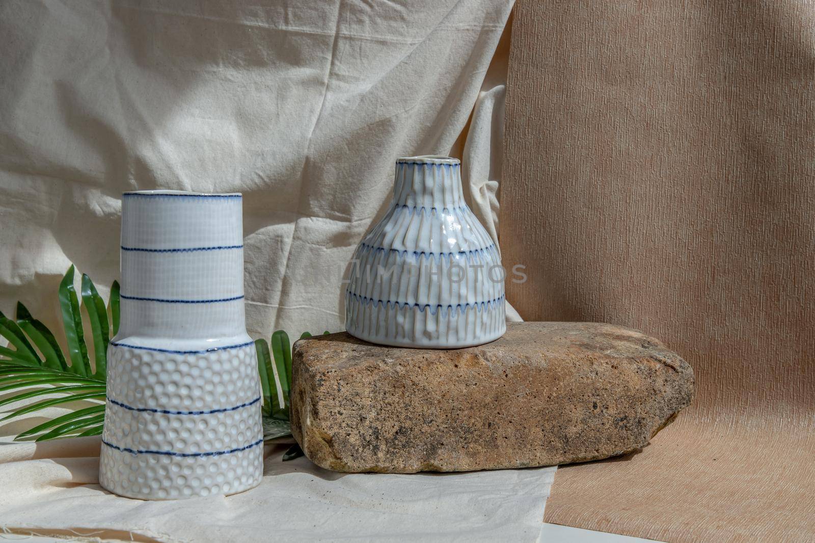 Two white handmade ceramic vases on white textured table cloth.  Home decor, Copy space, Selective focus.
