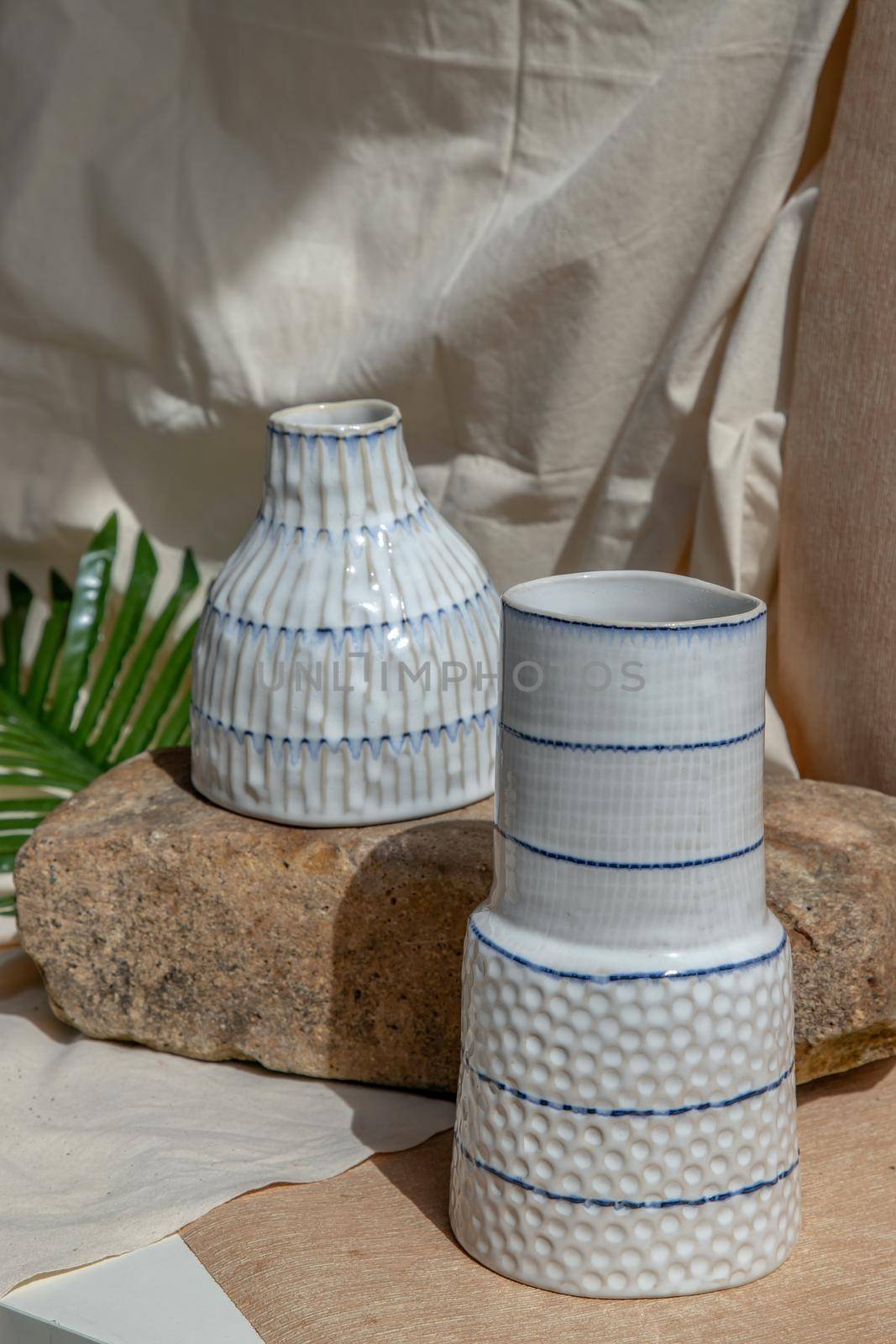 Two white handmade ceramic vases on white textured table cloth.  Home decor, Copy space, Selective focus.