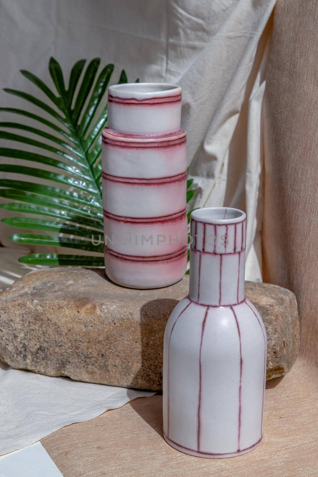 Two white and pink handmade ceramic vases on white textured table cloth.  Home decor, Copy space, Selective focus.