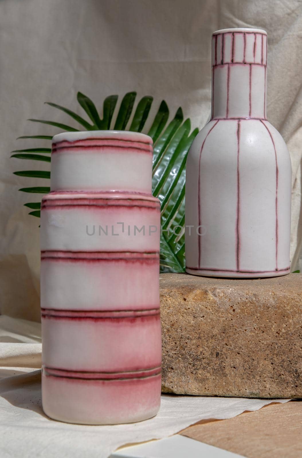 Two white and pink handmade ceramic vases on white textured table cloth.  Home decor, Copy space, Selective focus.