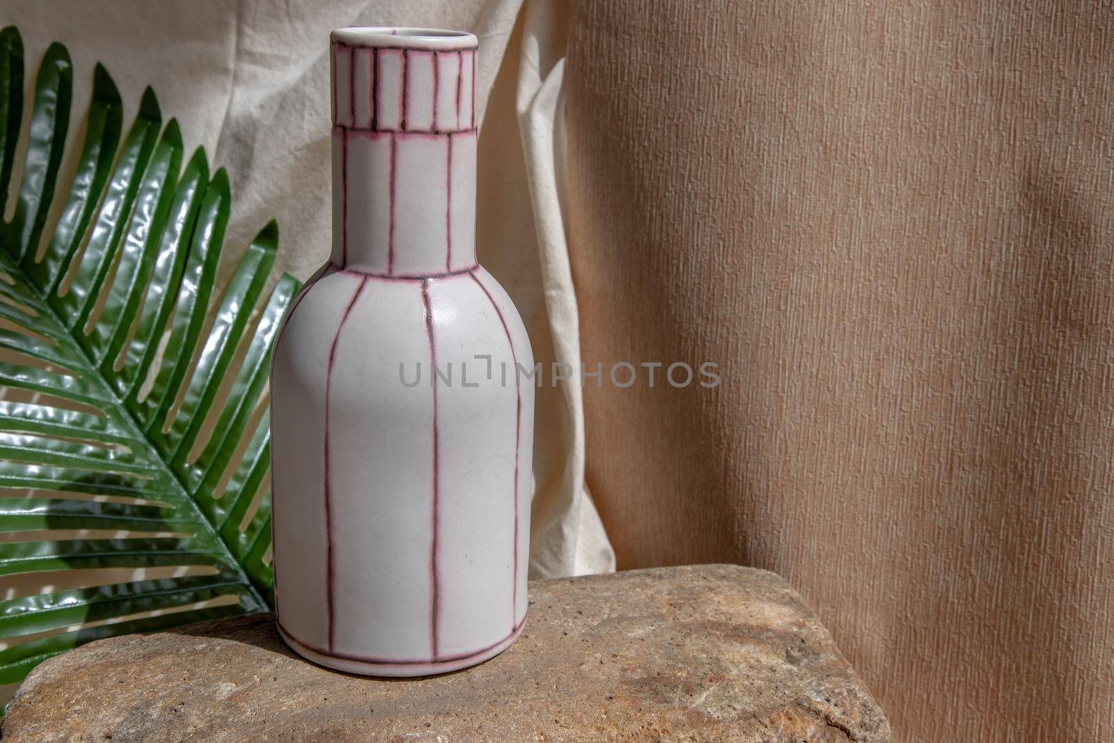 White and Pink handmade ceramic vase on white textured table cloth.  Home decor, Copy space, Selective focus.