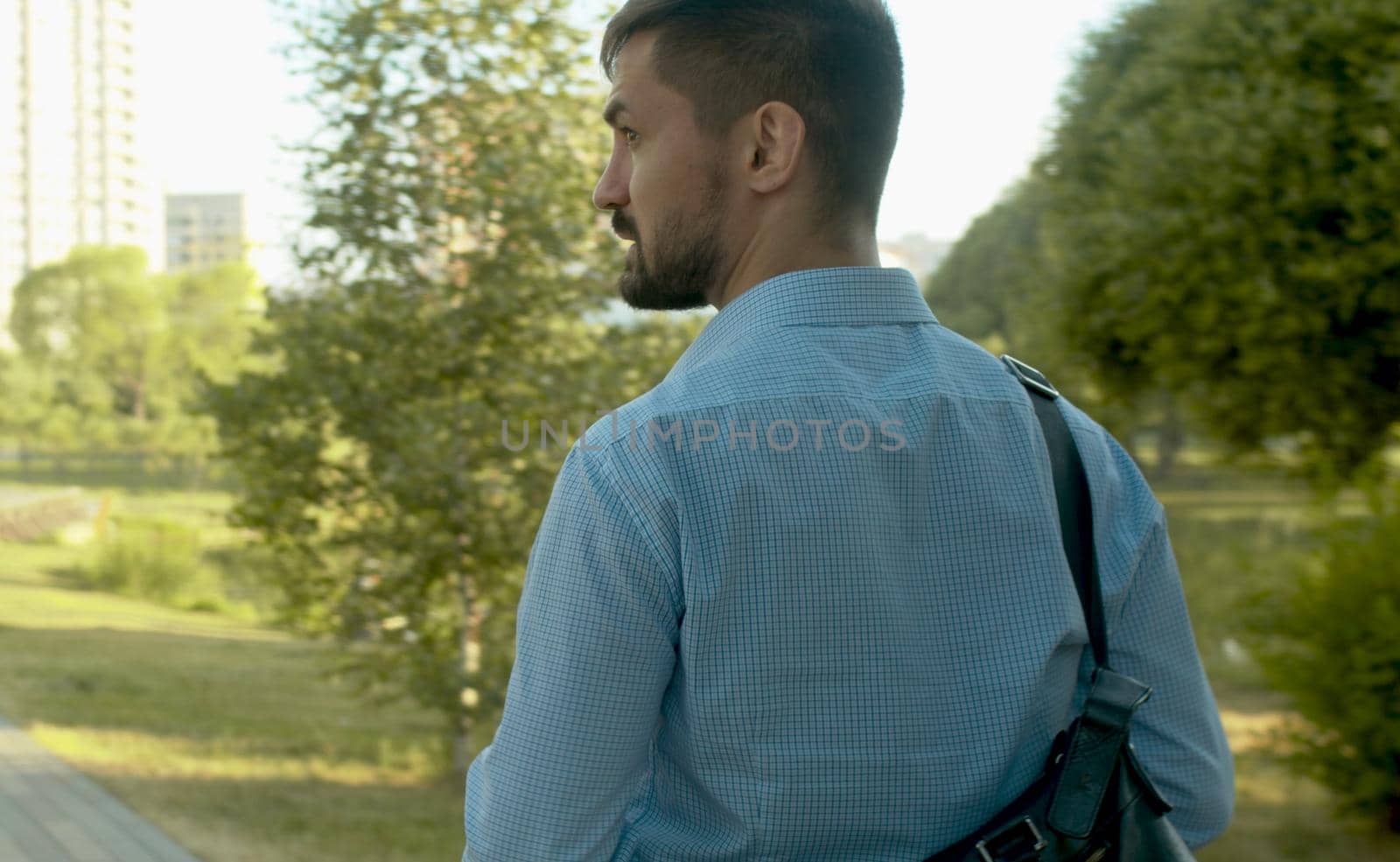 Rear view. Businessman walking in the park