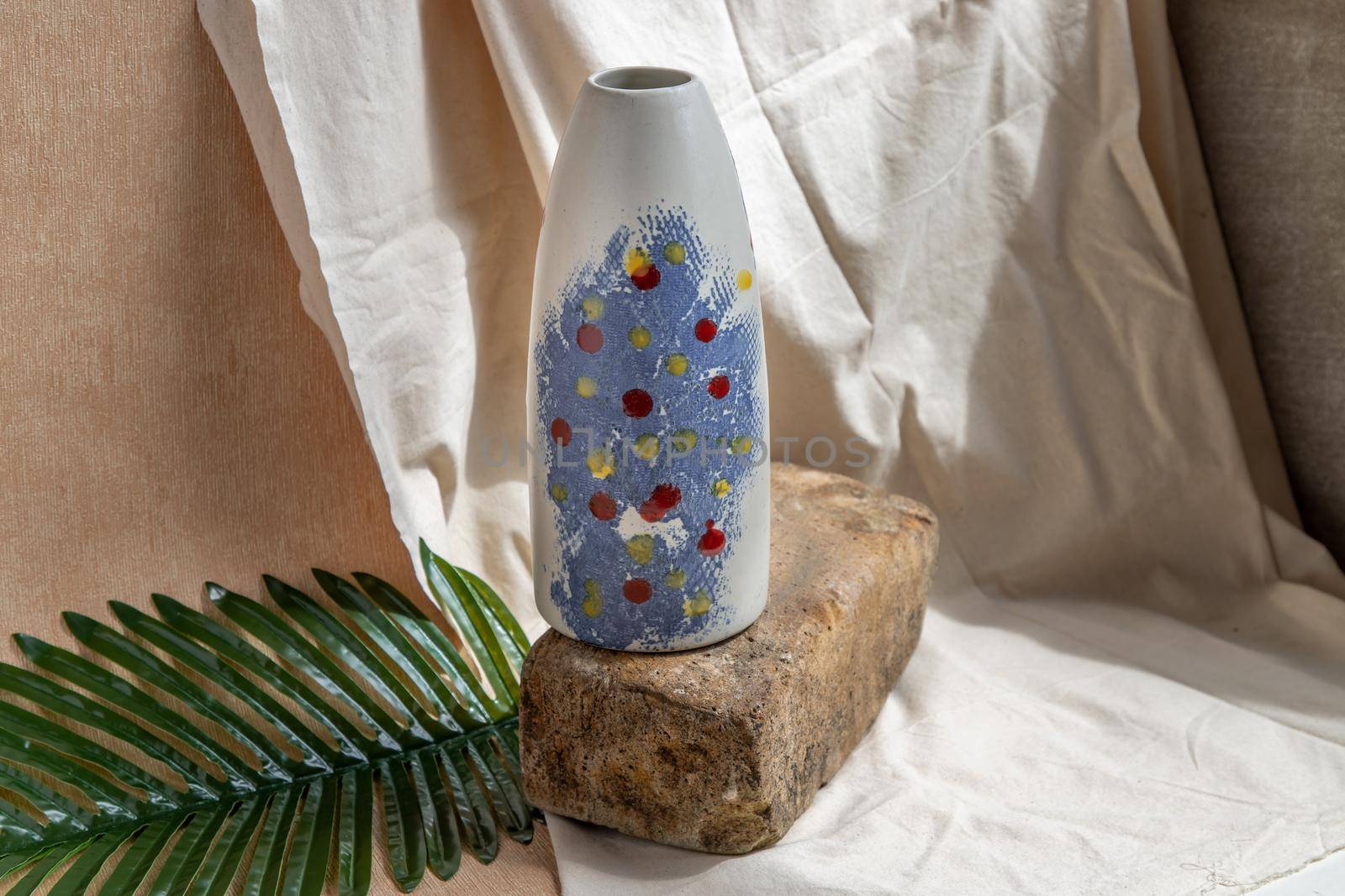 Blue and White handmade ceramic vase on white textured table cloth.  Home decor, Copy space, Selective focus.