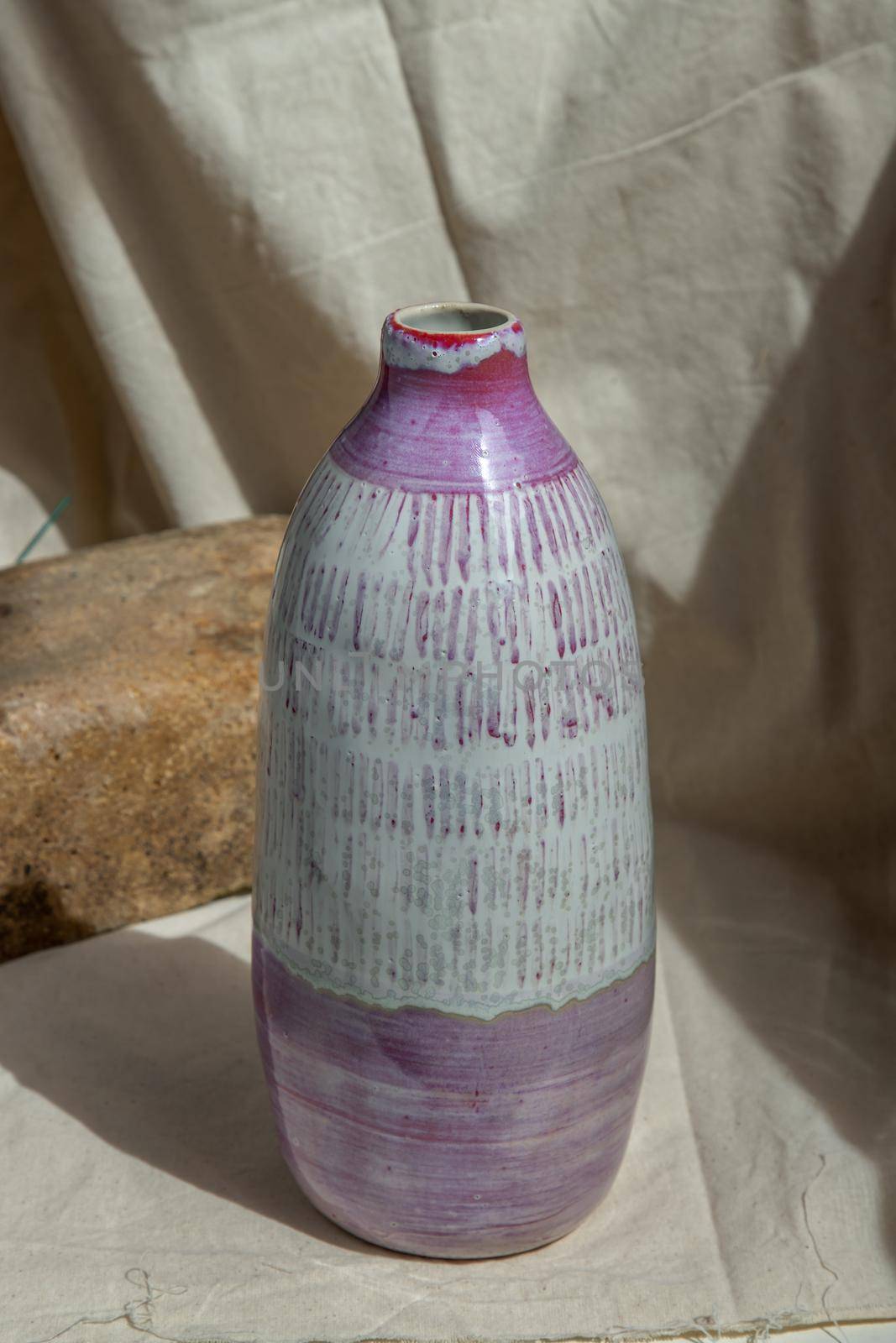 White and Pink Handmade ceramic vase on white textured table cloth. Home decor, Copy space, Selective focus.