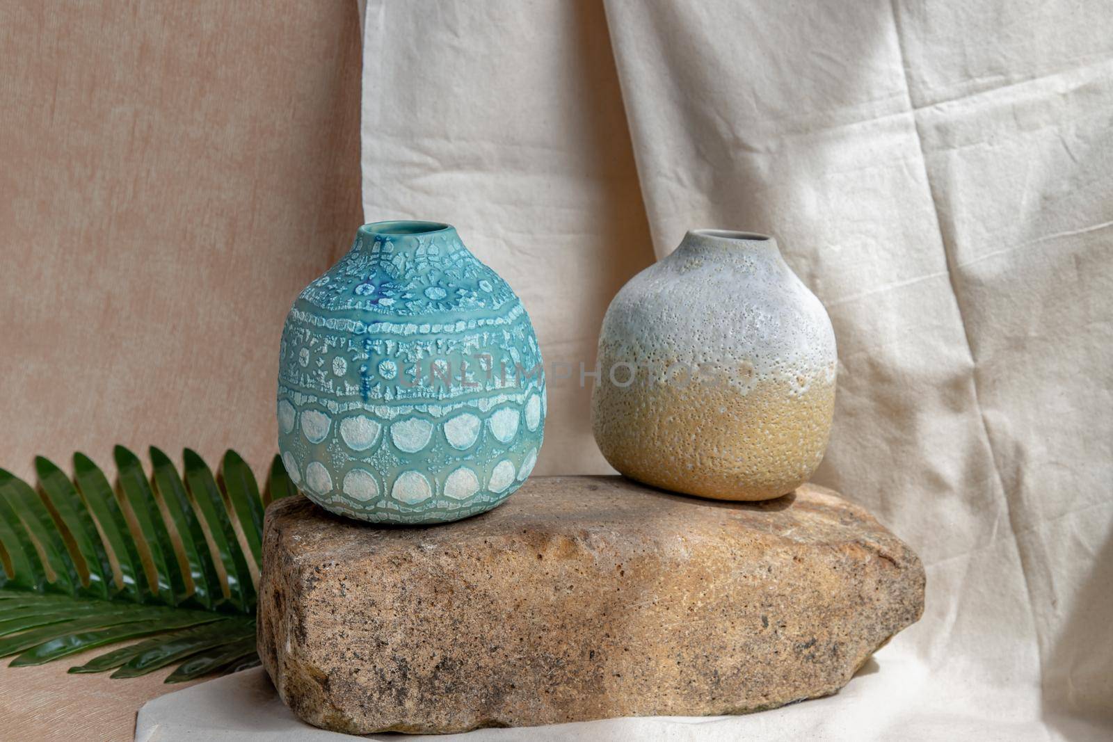 Two handmade ceramic vases on white textured table cloth. Home decor, Copy space, Selective focus.