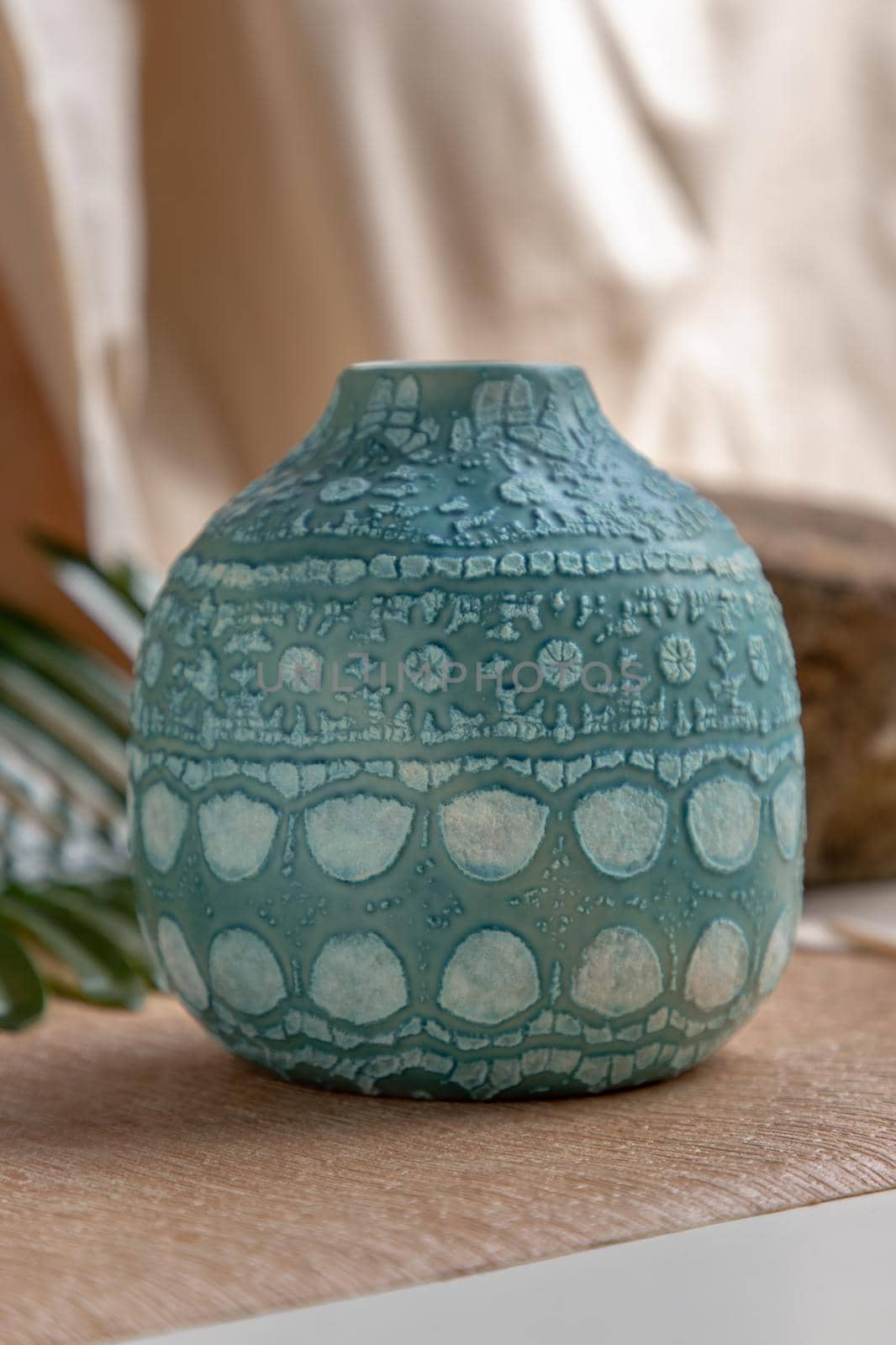 Blue handmade ceramic vase on white textured table cloth. Home decor, Copy space, Selective focus.