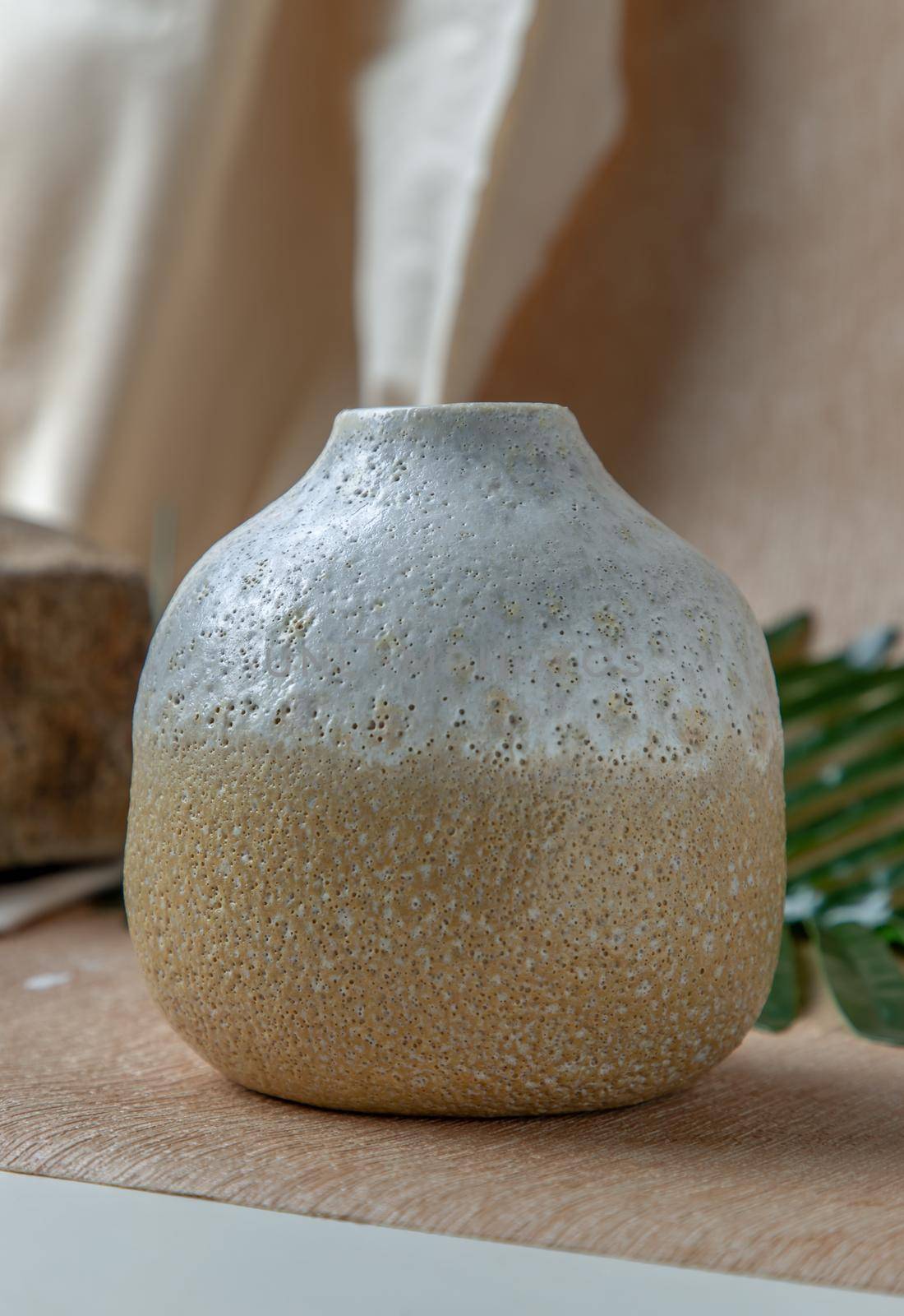 White and Yellow handmade ceramic vase on white textured table cloth. Home decor, Copy space, Selective focus.