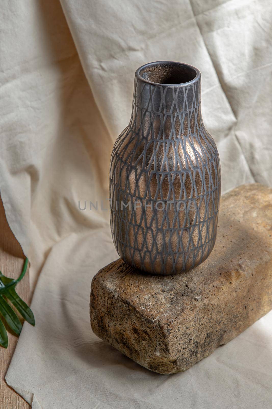 Copper color handmade ceramic vase on white textured table cloth. Home decor, Copy space, Selective focus.