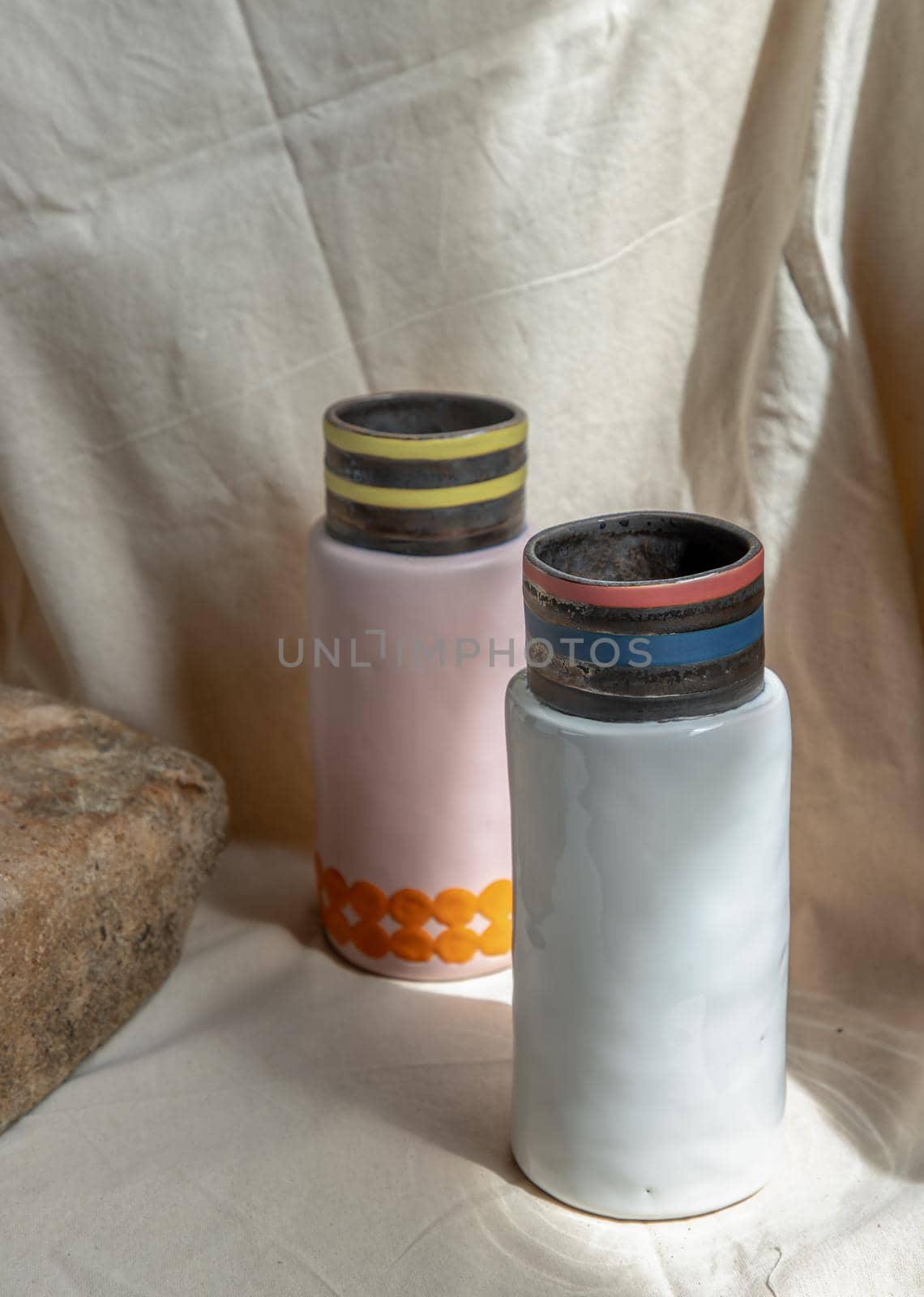 Two Pink and White handmade ceramic vases on white textured table cloth. Home decor, Copy space, Selective focus.