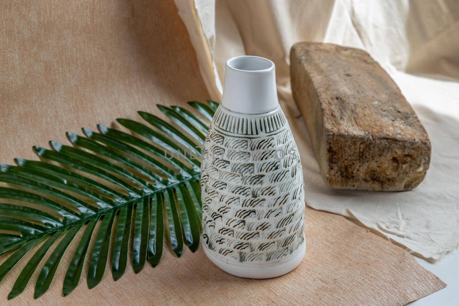 White and Black Handmade ceramic vase on white textured table cloth. Home decor, Copy space, Selective focus.