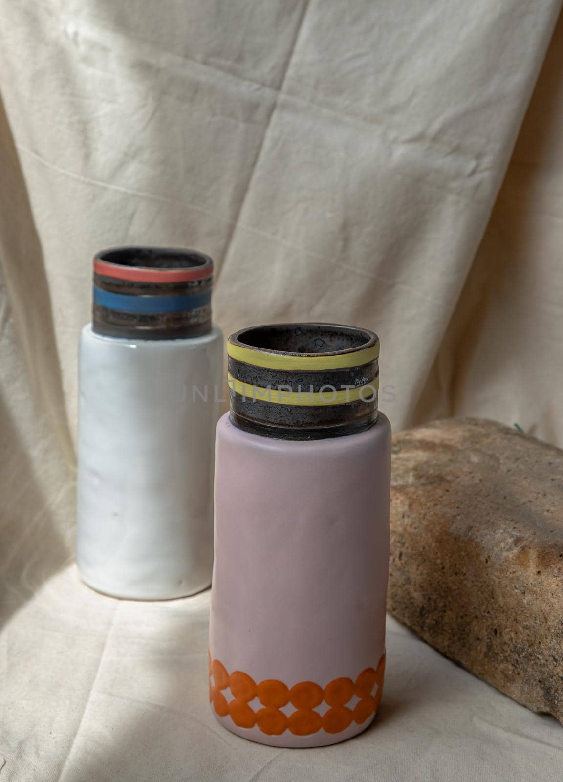 Two Pink and White handmade ceramic vases on white textured table cloth. Home decor, Copy space, Selective focus.
