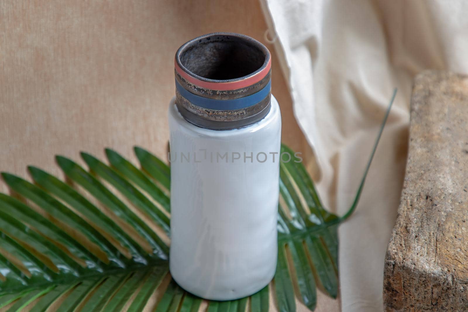 Pink handmade ceramic vase on white textured table cloth. Home decor, Copy space, Selective focus.