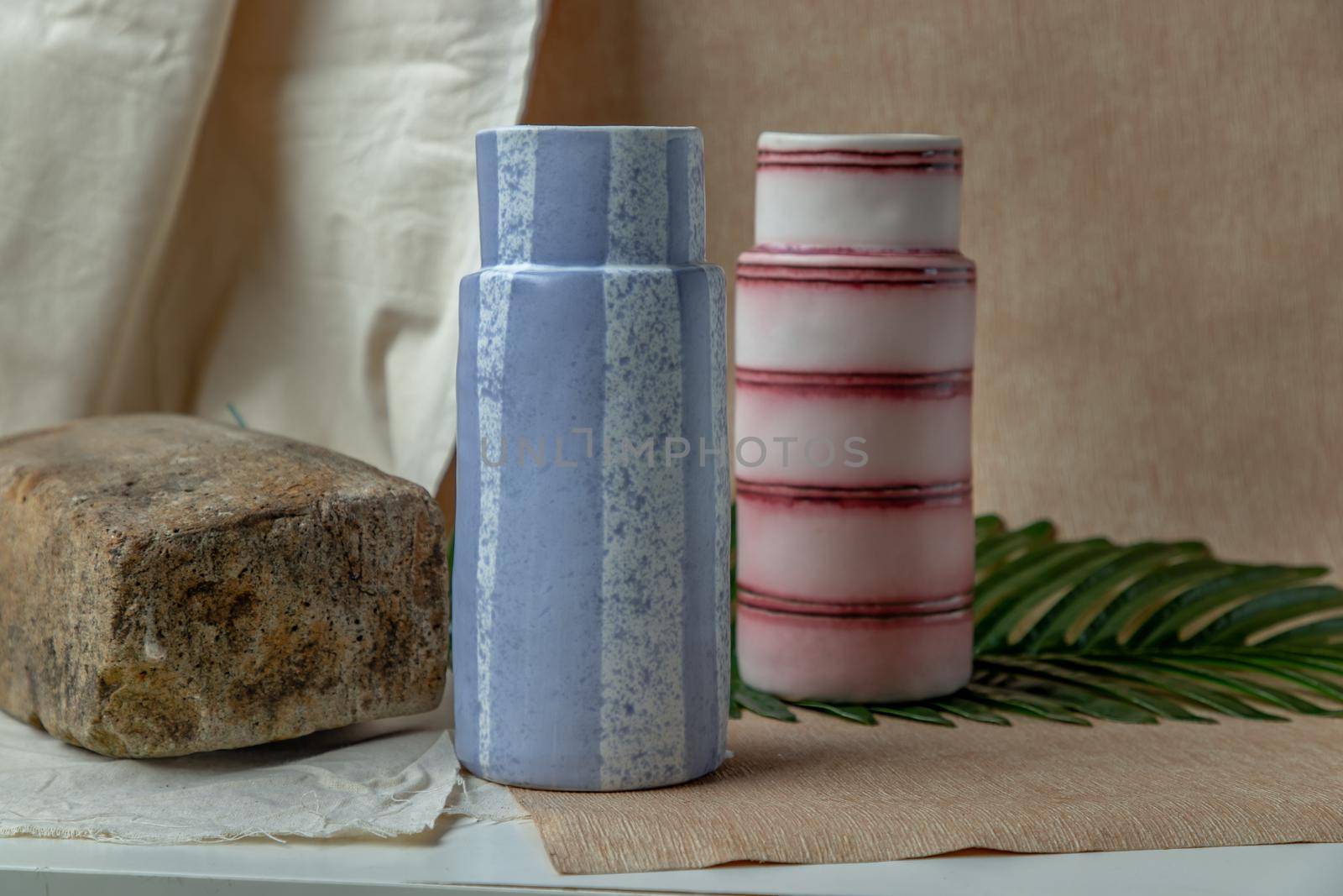Two handmade ceramic vases on white textured table cloth. Home decor, Copy space, Selective focus.