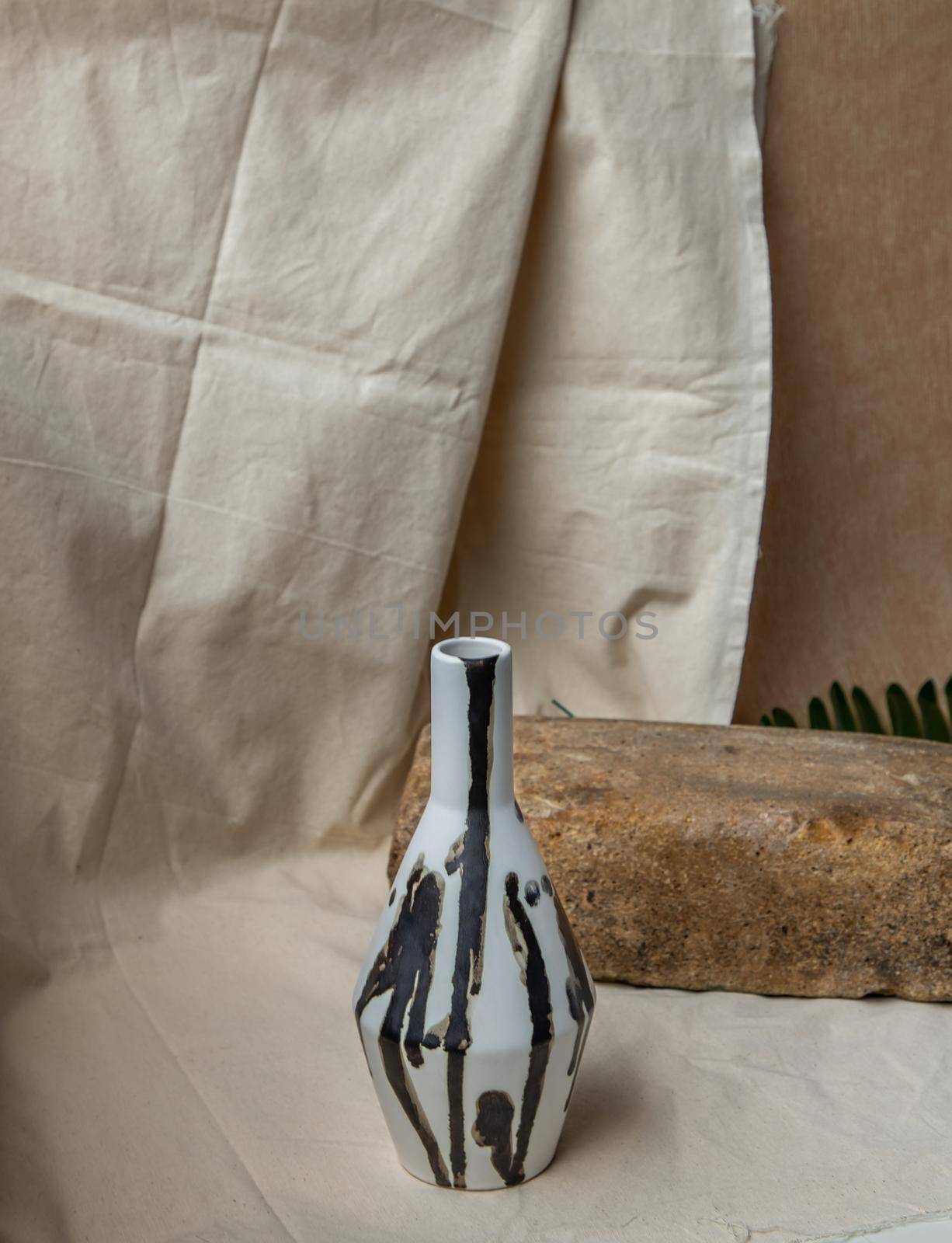 Black and White handmade ceramic vase on white textured table cloth. Home decor, Copy space, Selective focus.