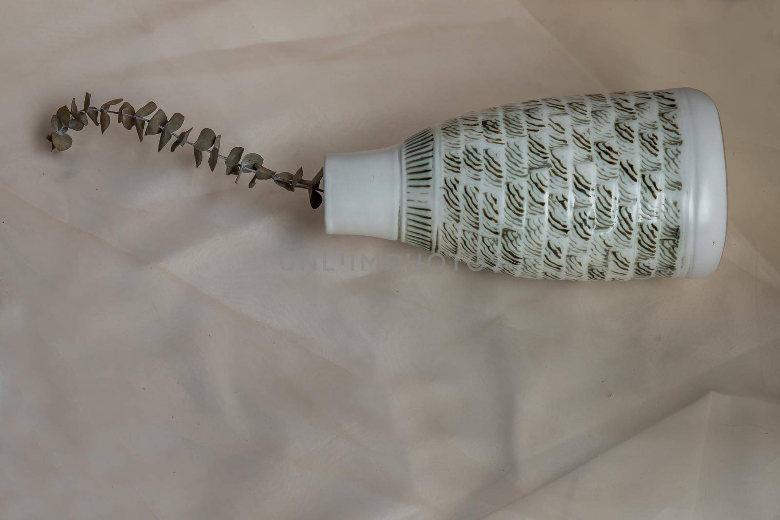 Dried flowers in White ceramic vase bottle shape on Blush textured table cloth. Home decor, Copy space, Selective focus.