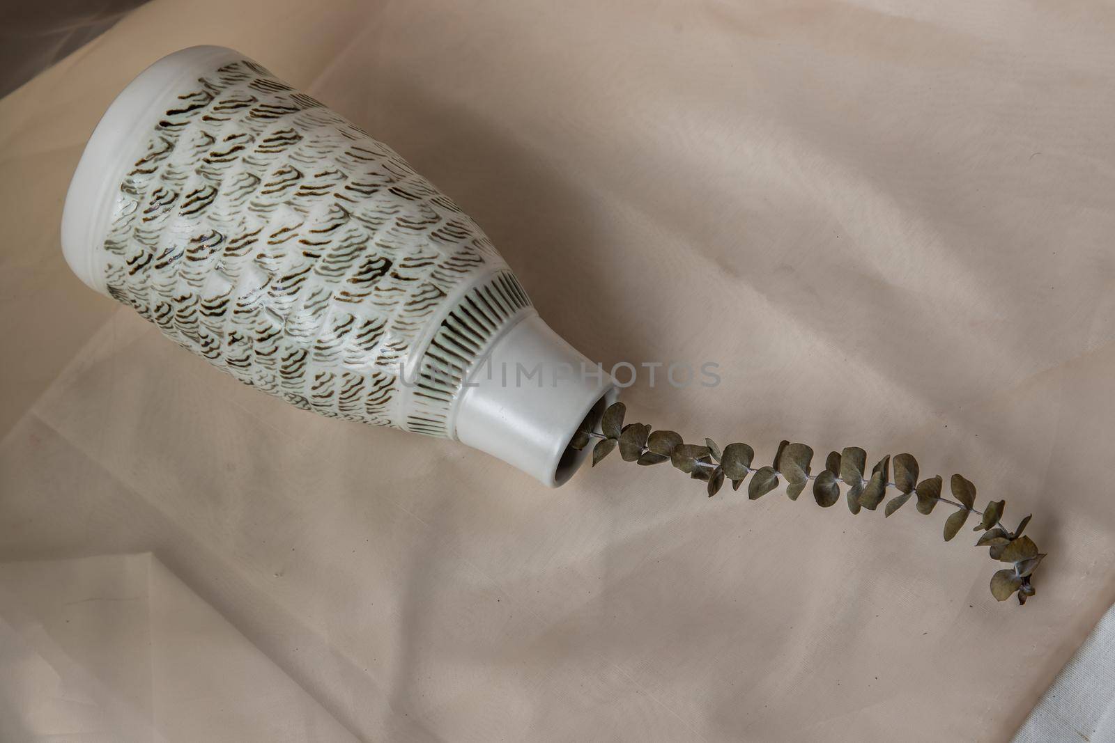 Dried flowers in White ceramic vase bottle shape on Blush textured table cloth. Home decor, Copy space, Selective focus.