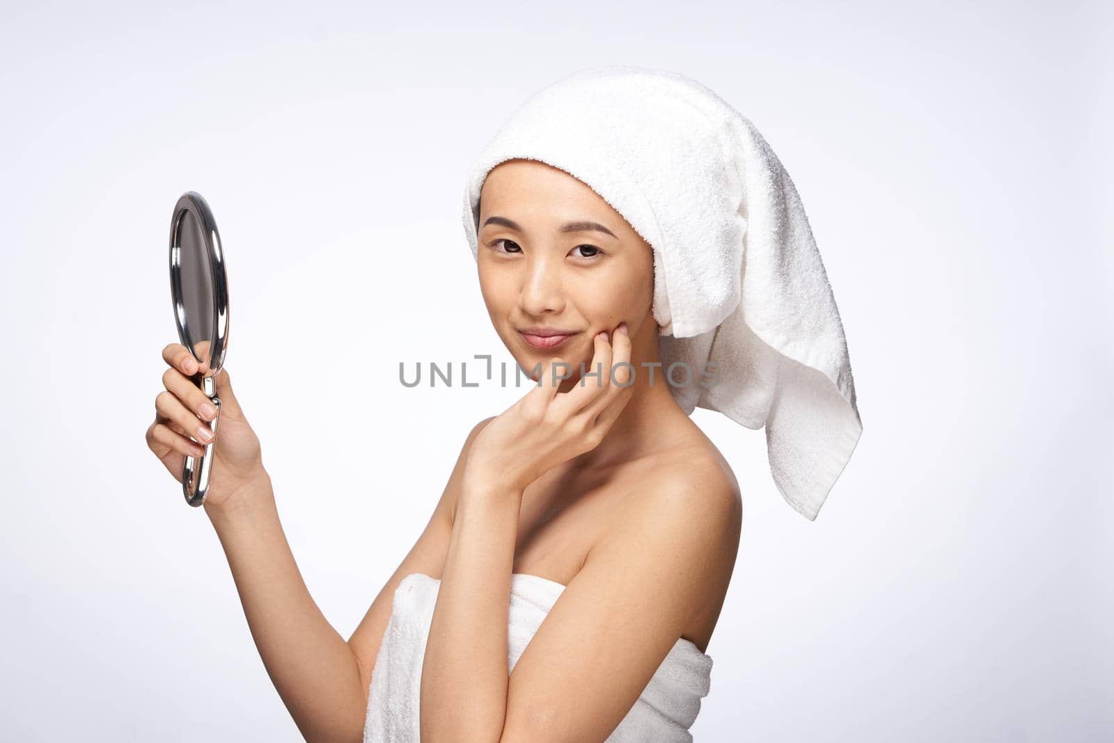 pretty asian woman in the mirror in trousers towel on head rejuvenation clear skin by SHOTPRIME