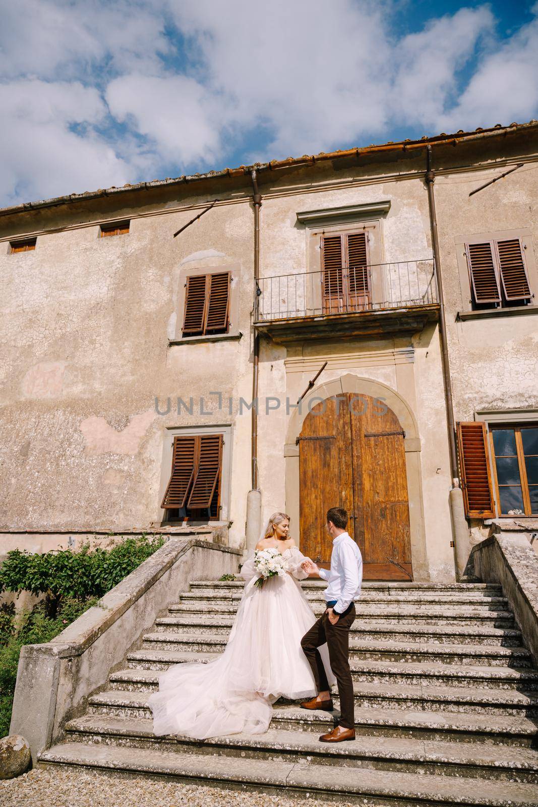 The wedding couple walks in the garden. Lovers of the bride and groom. Wedding in Florence, Italy, in an old villa-winery.