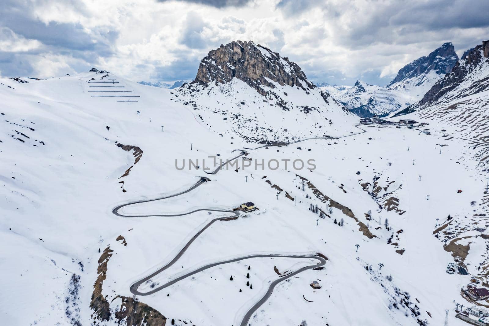 Aerial view of twisting road in the mountains of Italy, is serpentine among the snow-covered hills, is famous place among skiers and fans to understand a known by sports cars