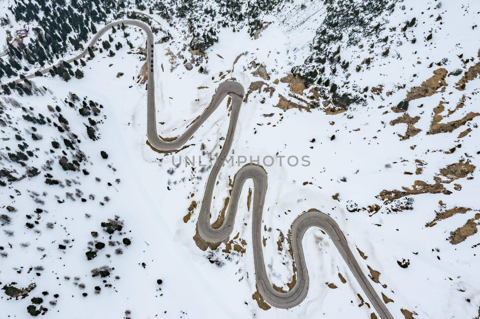 Aerial view of twisting road in the mountains of Italy, is serpentine among the snow-covered hills, is famous place among skiers and fans to understand a known by sports cars