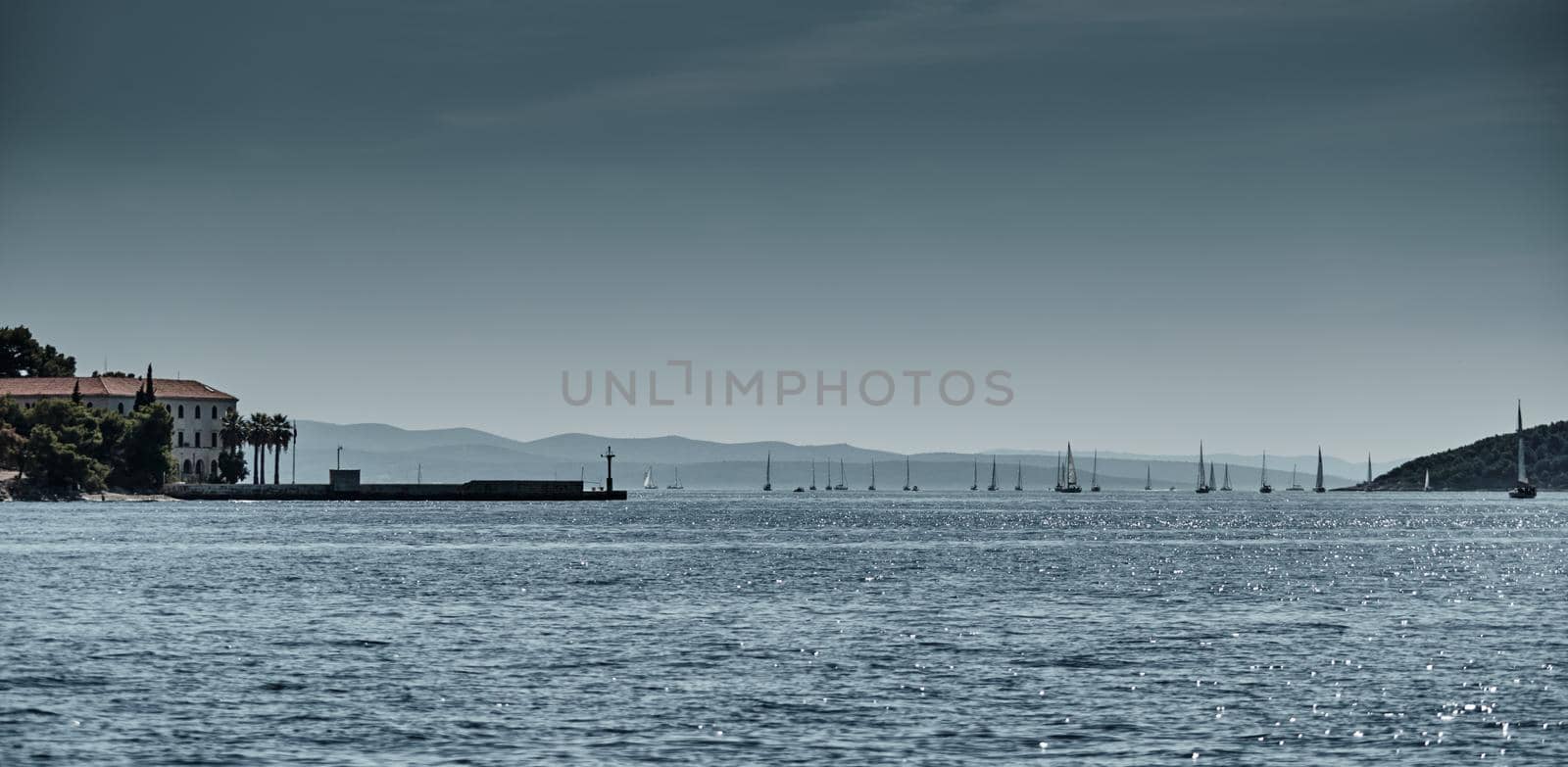 Beautiful sea landscape with sailboats, the race of sailboats on the horizon, a regatta, a Intense competition, island with windmills are on background