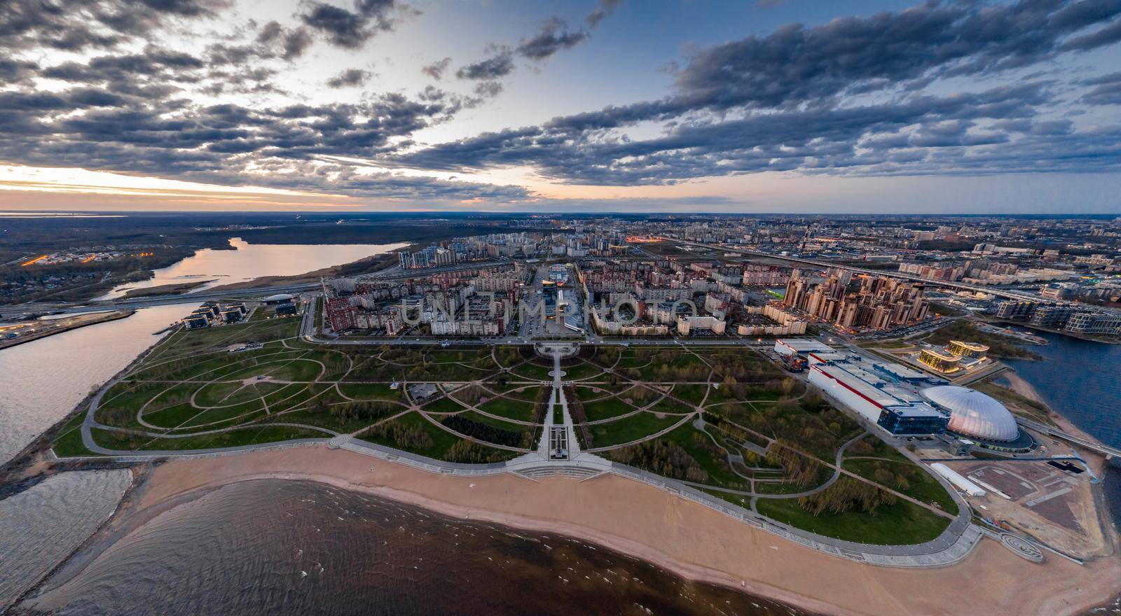 Russia, St.Petersburg, 06 May 2020: Aerial panoramic image of Primorskiy district at sunset, Park of 300 anniversaries, trade center Piterland, public beach, night illumination , dusk