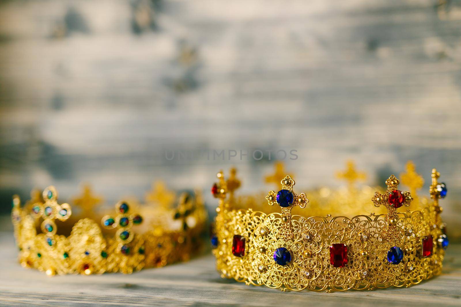 Two golden crowns encrusted with precious stones for a religious wedding in an Orthodox church