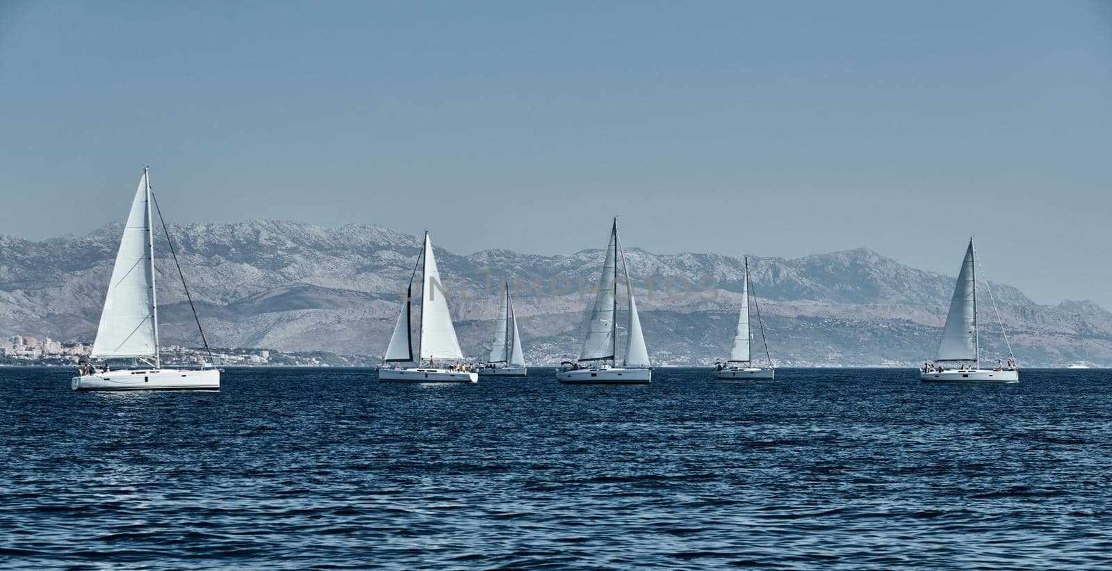 Beautiful sea landscape with sailboats, the race of sailboats on the horizon, a regatta, a Intense competition, island with windmills are on background