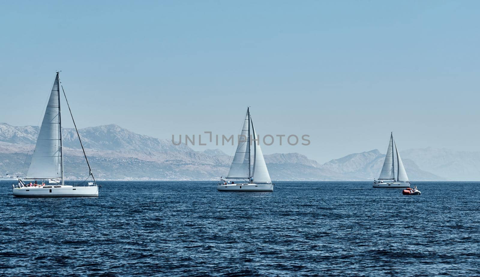 Beautiful sea landscape with sailboats, the race of sailboats on the horizon, a regatta, a Intense competition, island with windmills are on background