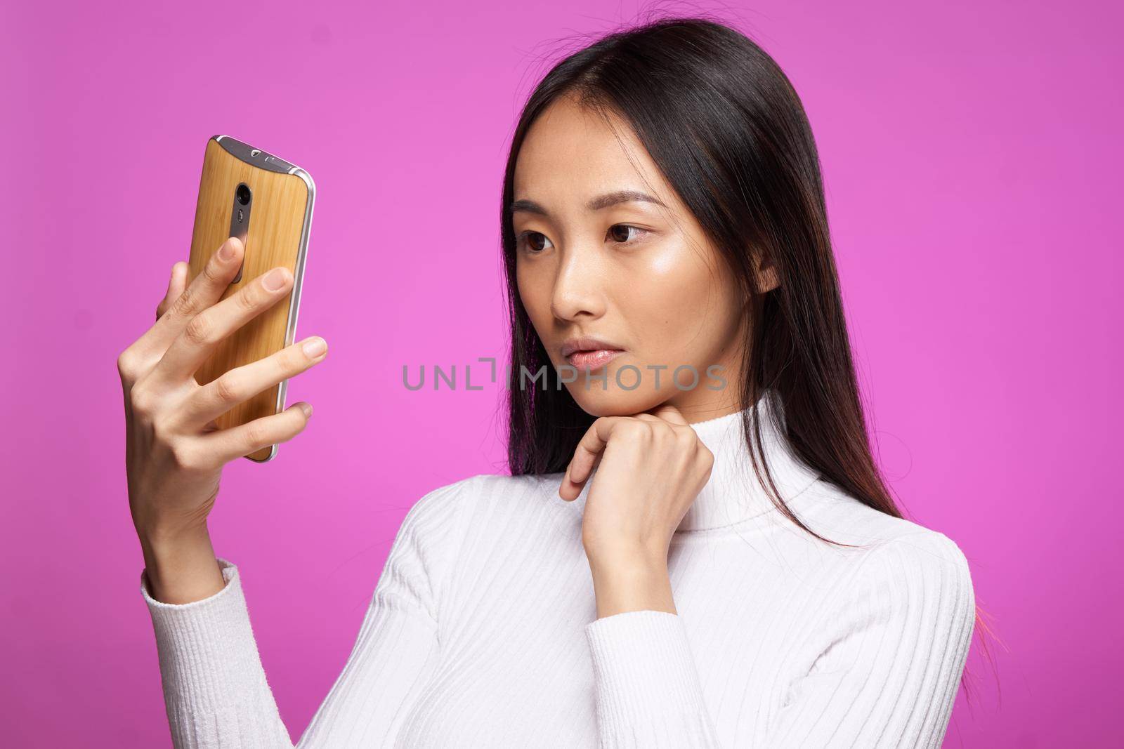 asian woman holding phone he communication technology internet pink background. High quality photo