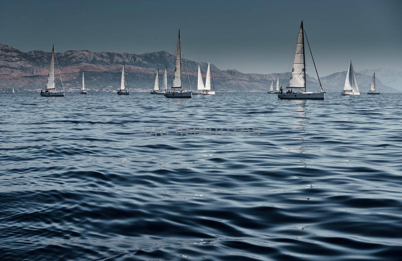 Beautiful sea landscape with sailboats, the race of sailboats on the horizon, a regatta, a Intense competition, island with windmills are on background