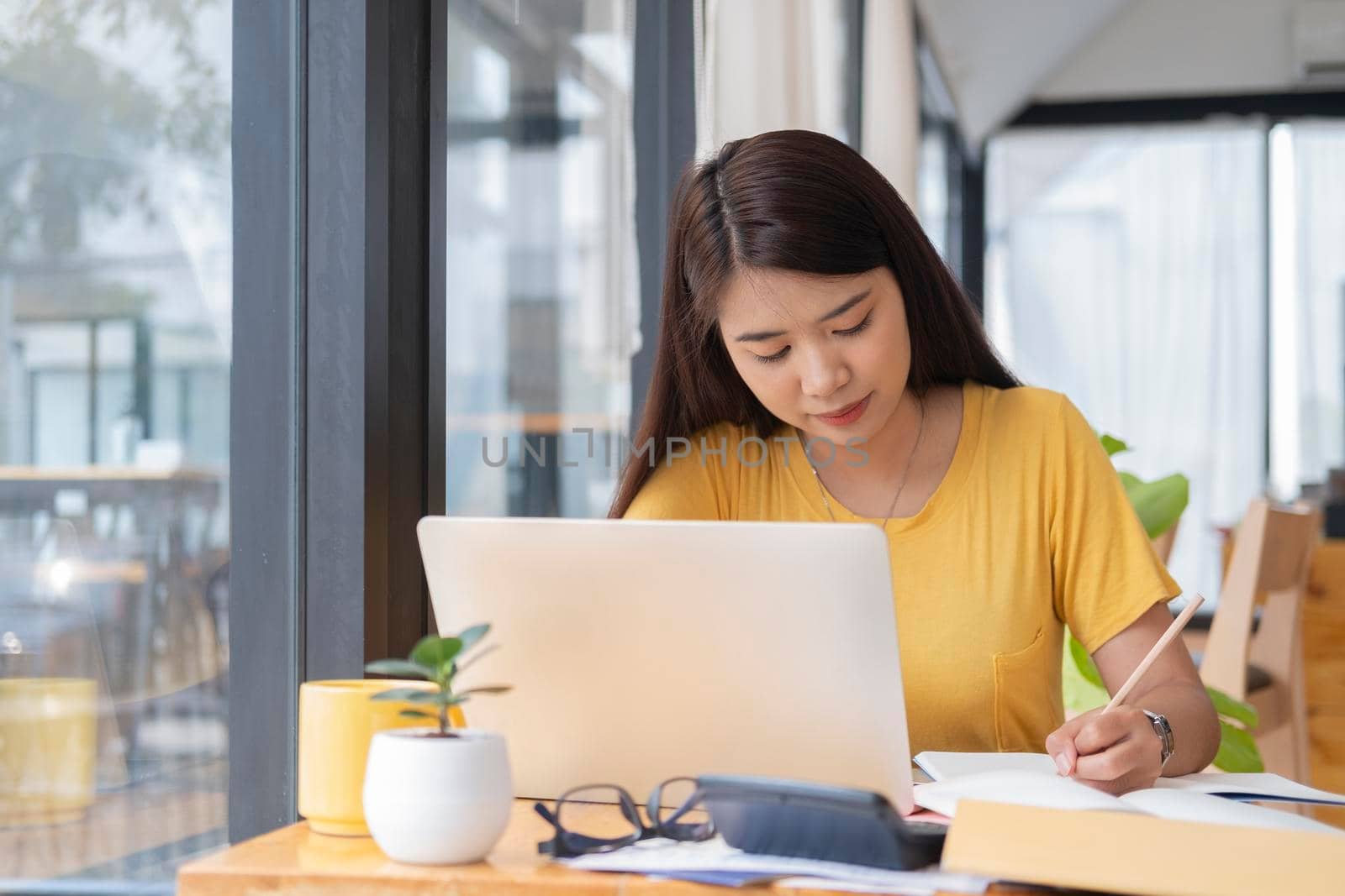 Young collage student using computer and mobile device studying online. Education and online learning. 