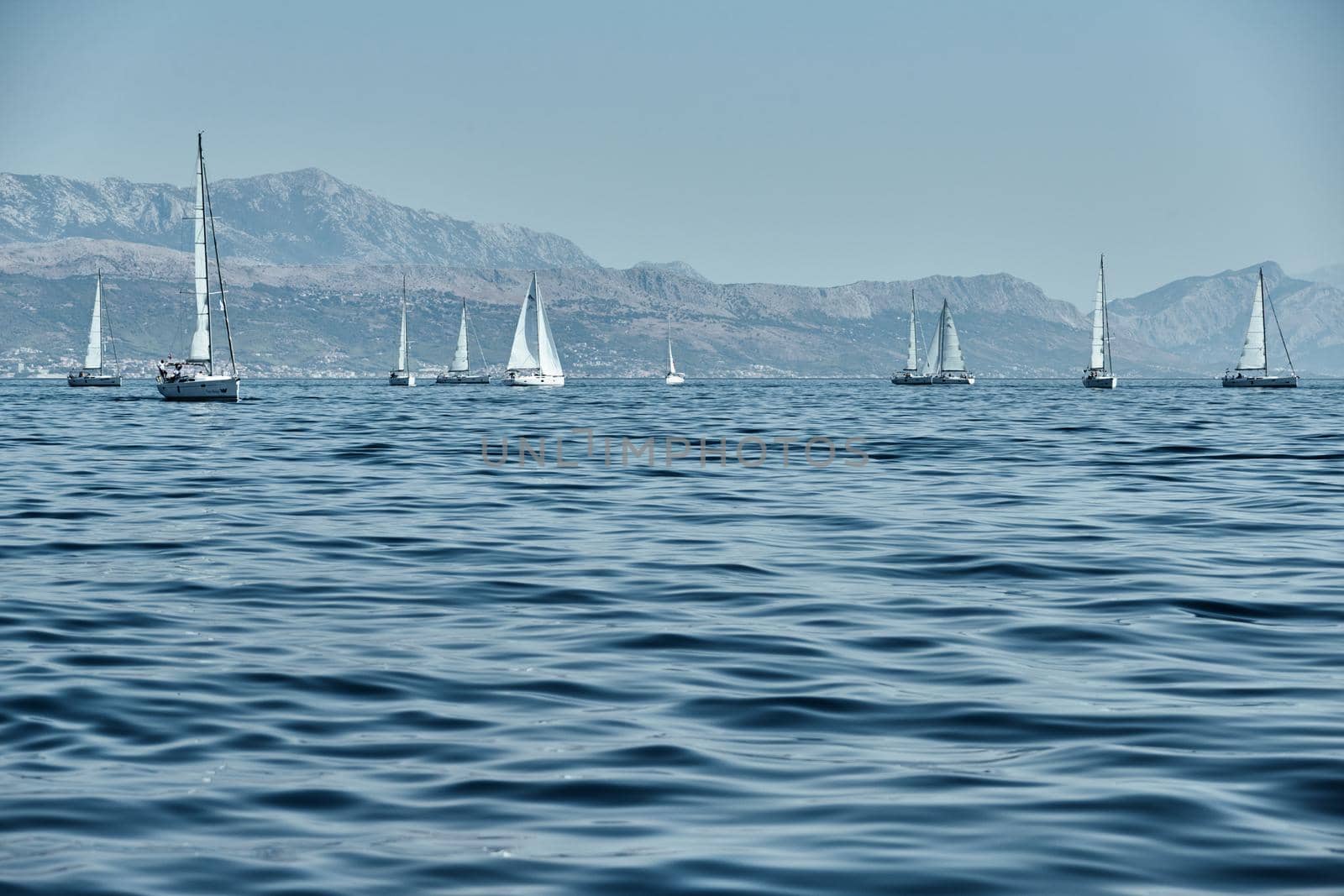 Beautiful sea landscape with sailboats, the race of sailboats on the horizon, a regatta, a Intense competition, island with windmills are on background