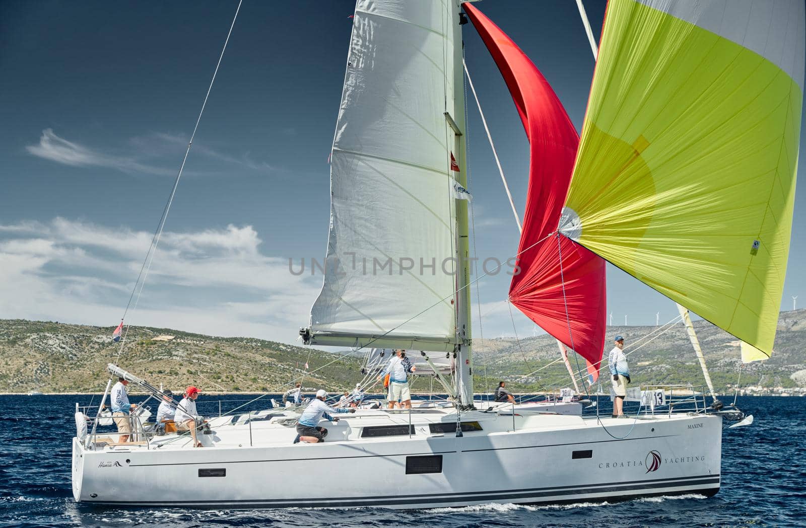 Croatia, Mediterranean Sea, 18 September 2019: The team of sailboat turns off the boat, sailboats compete in a sail regatta, The team works, pulls to a rope, the captain stands behind a steering wheel