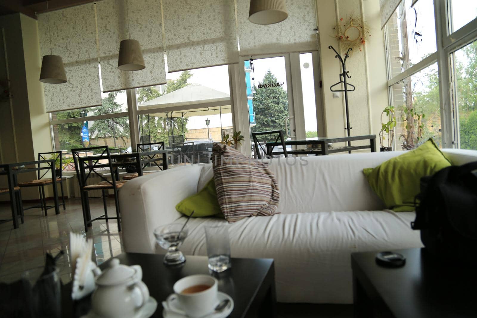 A cozy cafe with a soft sofa and beautiful interior and panoramic windows.