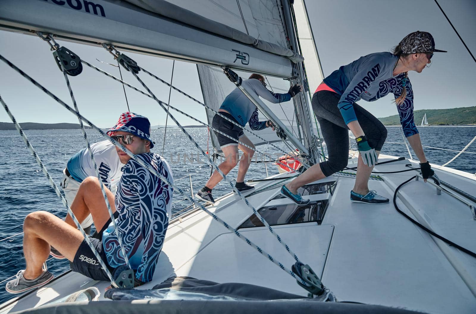 Croatia, Mediterranean Sea, 18 September 2019: The team of sailboat turns off the boat, sailboats compete in a sail regatta, The team works, pulls to a rope, a steering wheel, multicolored spinnakers by vladimirdrozdin