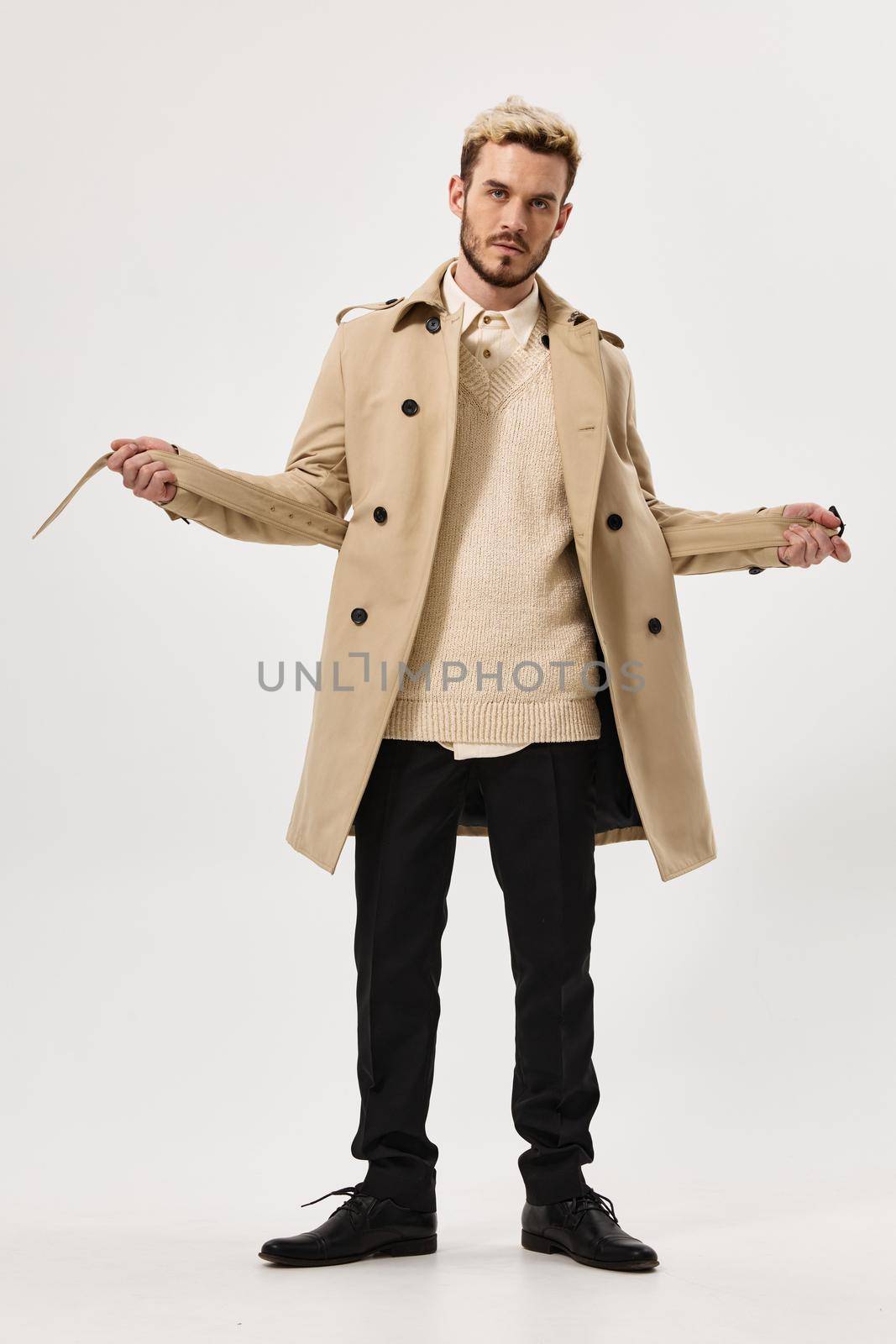 man in a beige coat fashionable hairstyle for autumn style Studio in full growth by SHOTPRIME