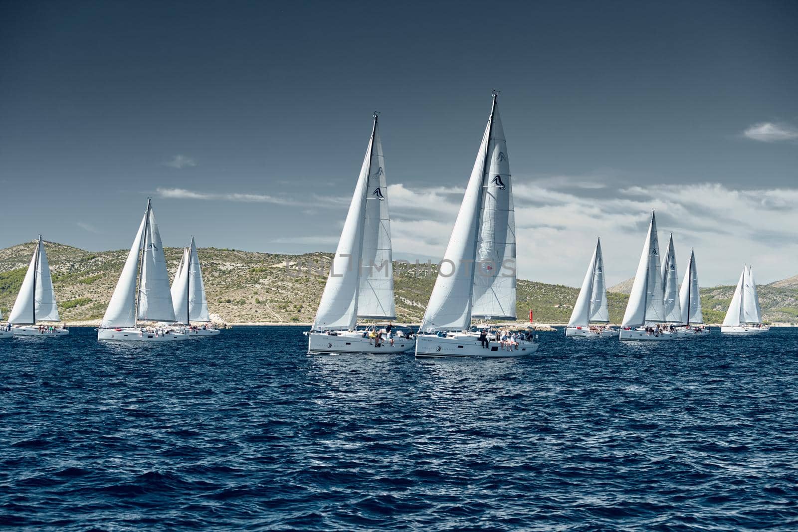 Croatia, Mediterranean Sea, 18 September 2019: The team of sailboat turns off the boat, sailboats compete in a sail regatta, The team works, pulls to a rope, a steering wheel, multicolored spinnakers by vladimirdrozdin