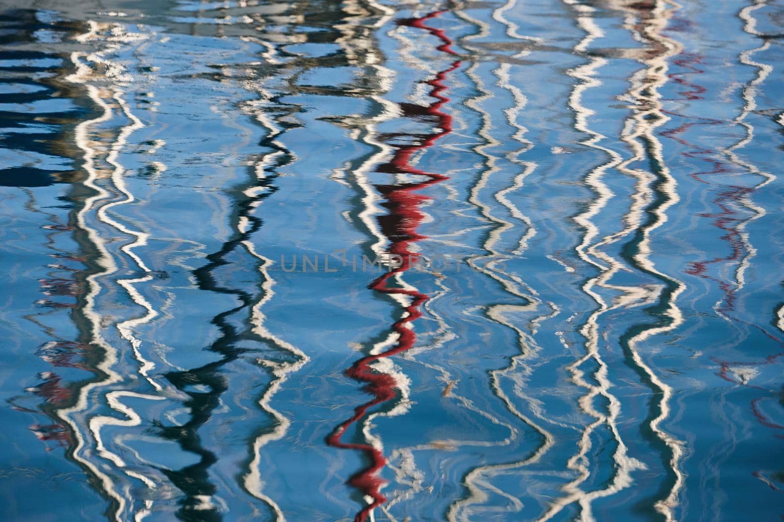 Reflection of masts of sailboats on water, interesting texture, smooth lines of water, a sail regatta, reflection of masts on water, ropes and aluminum