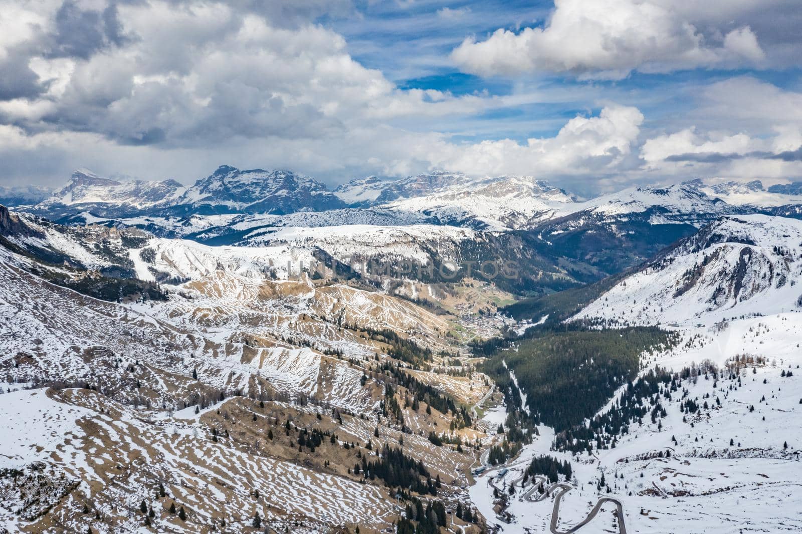 Aerial view of twisting road in the mountains of Italy, is serpentine among the snow-covered hills, is famous place among skiers and fans to understand a known by sports cars, mountains peak by vladimirdrozdin