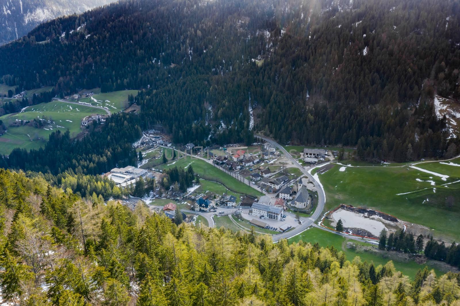 Aerial view of huge valley of the mountains of Italy, Trentino, green meadows, Slopes with green spruce trees, Dolomites on background, The town in the bottom of a valley by vladimirdrozdin