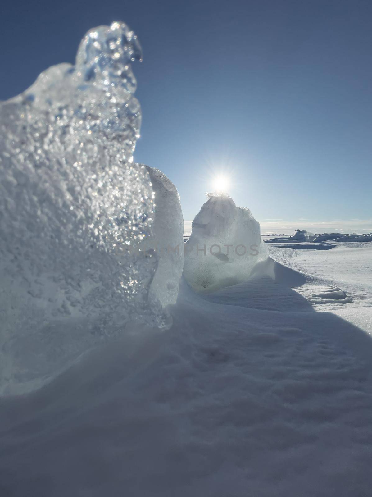 Ice slopes in sunny winter day, transparent ice of blue color, purely blue sky, long shadows, a pure snow-covered virgin soil, snow barkhans, . High quality photo