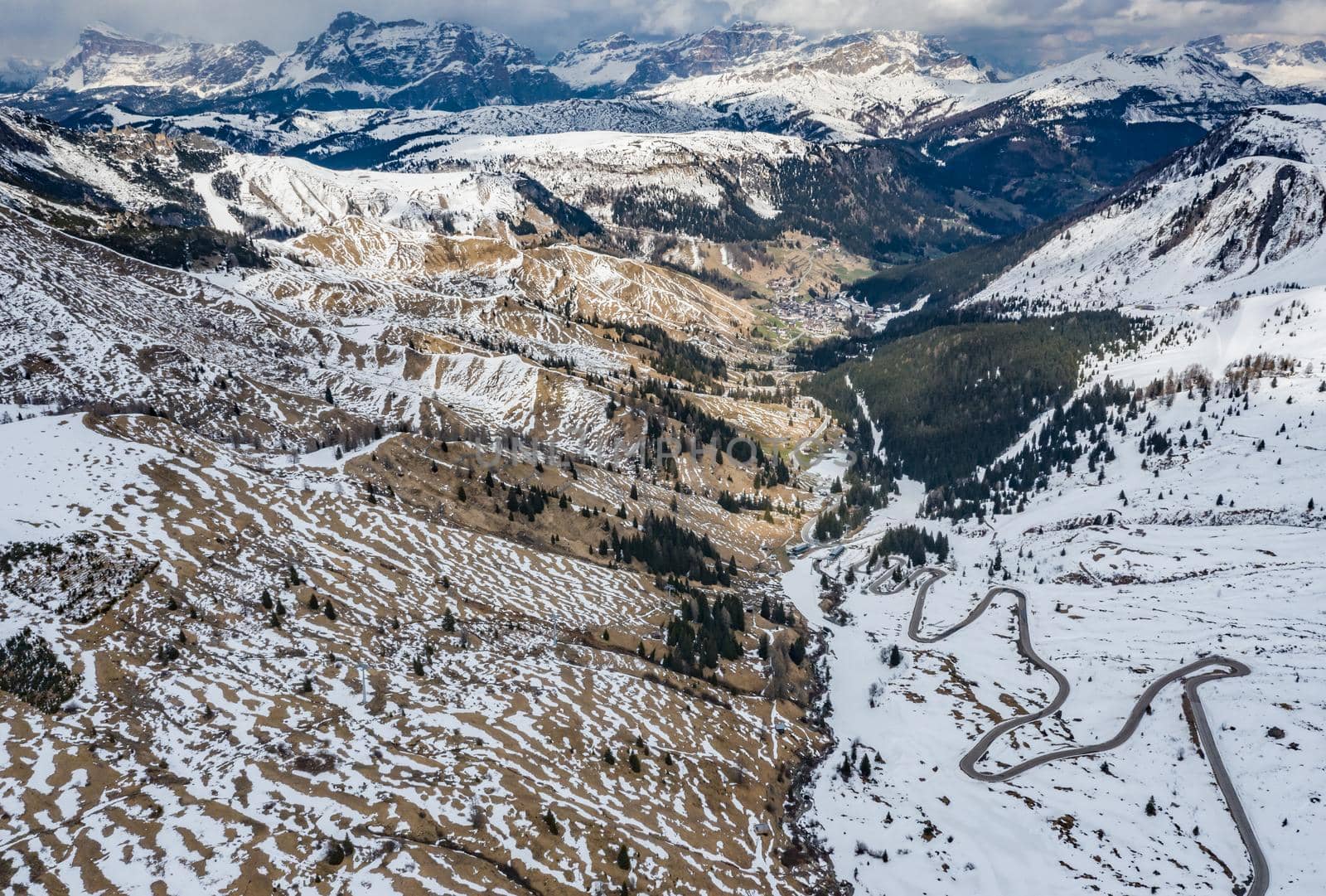 Aerial view of twisting road in the mountains of Italy, is serpentine among the snow-covered hills, is famous place among skiers and fans to understand a known by sports cars, mountains peak by vladimirdrozdin